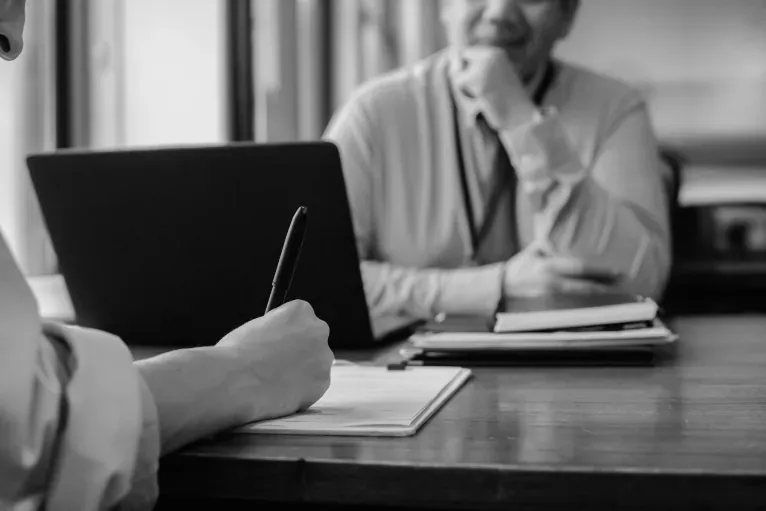An asset owner reviewing documents with another person.