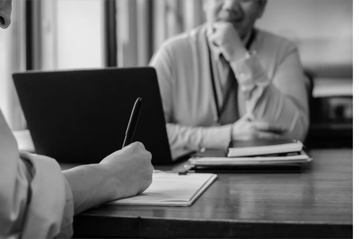 An asset owner reviewing documents with another person.